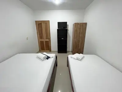 a room with two beds and a tv in it at Apartamento la Isla 1-Coveñas in Coveñas