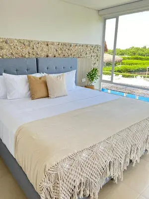 a bedroom with a large bed with a large window at Santo Manglar Cartagena Life Wellness Spa Hotel in Cartagena de Indias