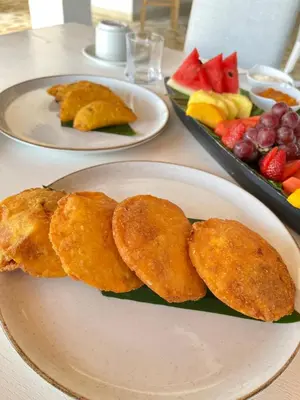 a table with two plates of food and a plate of fruit at Santo Manglar Cartagena Life Wellness Spa Hotel in Cartagena de Indias