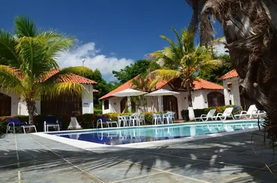 a resort with a swimming pool with chairs and palm trees at Condominio Atlantis in Coveñas