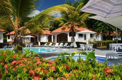 a resort with a pool and chairs and palm trees at Condominio Atlantis in Coveñas