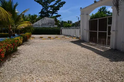 a gravel driveway with a gate and a fence at Condominio Atlantis in Coveñas