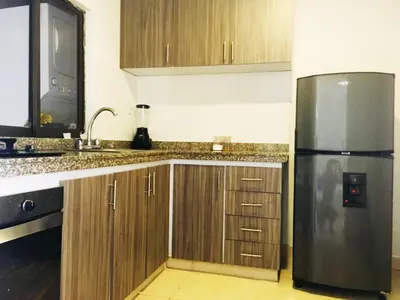 a kitchen with a stainless steel refrigerator and wooden cabinets at SAN JACINTO HOSTEL in Cartagena de Indias