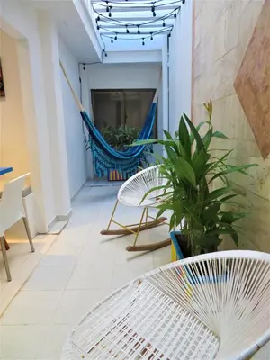 a patio with a hammock and chairs and a table at SAN JACINTO HOSTEL in Cartagena de Indias