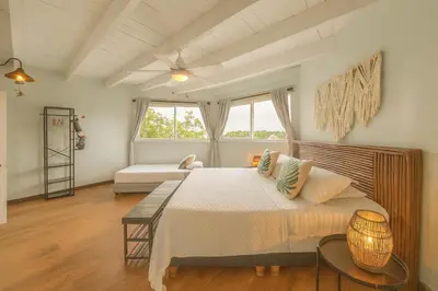 a bedroom with a large bed and a couch at Fragata Island House in Isla Grande