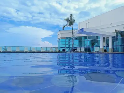 a swimming pool in front of a building with a fountain at Apartamentos Palmetto - Frente al Mar in Cartagena de Indias