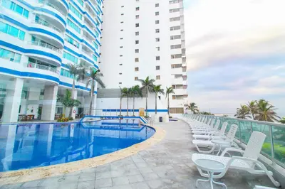 a hotel swimming pool with chairs and a building at Apartamentos Palmetto - Frente al Mar in Cartagena de Indias