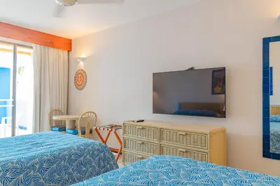 a bedroom with two beds and a flat screen tv at Zuana Beach Resort in Santa Marta