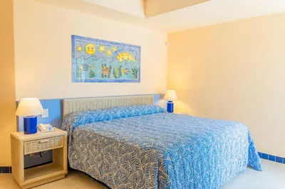 a bedroom with a bed and a painting on the wall at Zuana Beach Resort in Santa Marta