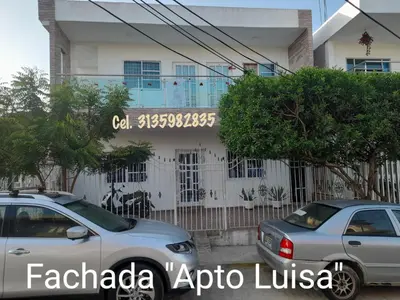 two cars parked in front of a building at Apartamentos LUISA in Coveñas