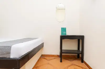 a bedroom with a bed and a side table at Hotel Itaka in Soledad