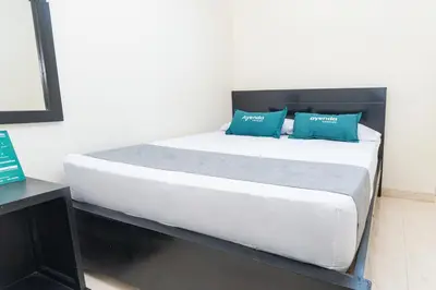 a bed in a room with blue pillows on it at Hotel Itaka in Soledad