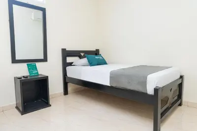 a bedroom with a bed with a mirror and a table at Hotel Itaka in Soledad