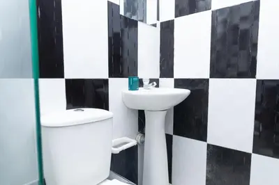 a bathroom with a toilet and a sink at Hotel Itaka in Soledad