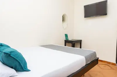 a bedroom with a bed and a flat screen tv at Hotel Itaka in Soledad