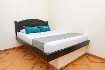 a bed with blue pillows in a room at Hotel Itaka in Soledad