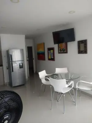 a dining room with a table and a refrigerator at 1C5 APARTAMENTO EN CARTAGENA CON BALCON Y VISTA AL MAR, AIRE ACONDICIONADO Y WIFi in Cartagena de Indias