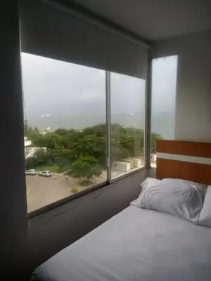 a bedroom with a bed and a large window at 1C5 APARTAMENTO EN CARTAGENA CON BALCON Y VISTA AL MAR, AIRE ACONDICIONADO Y WIFi in Cartagena de Indias