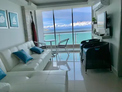 a living room with a white couch and a view of the ocean at apartamento 807 moderno en el laguito, vista al mar in Cartagena de Indias