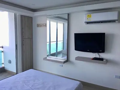 a bedroom with a flat screen tv on a wall at apartamento 807 moderno en el laguito, vista al mar in Cartagena de Indias