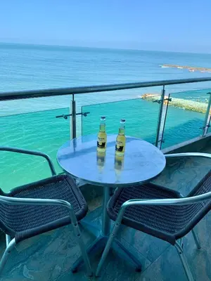 two bottles of beer sitting on a table next to the ocean at apartamento 807 moderno en el laguito, vista al mar in Cartagena de Indias