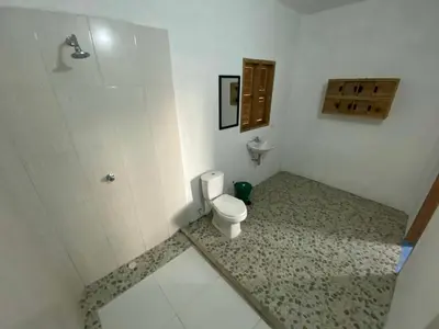 a bathroom with a toilet and a shower at Rainbow Hostel in San Bernardo del Viento
