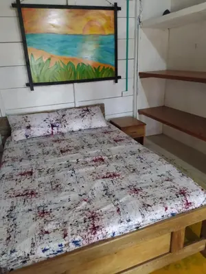 a bed in a room with a painting on the wall at Rainbow Hostel in San Bernardo del Viento