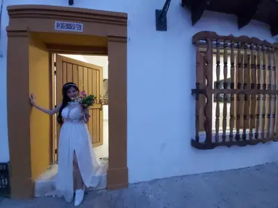 a woman in a white dress standing next to a building at APTO INTERIOR in Cartagena de Indias