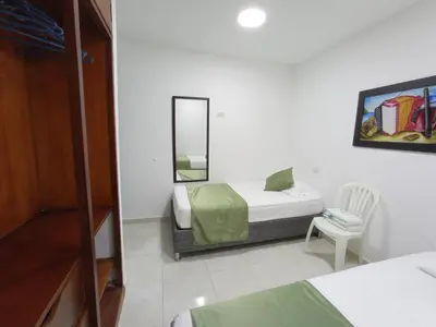 a bedroom with a bed and a mirror and a chair at APTO INTERIOR in Cartagena de Indias