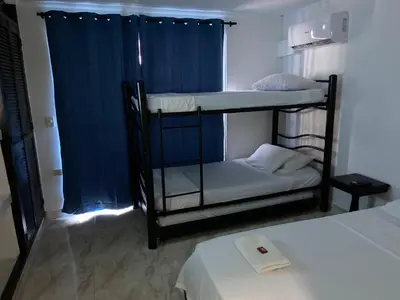 a room with two bunk beds and a blue curtain at Hotel Blue Diamond House in Cartagena de Indias