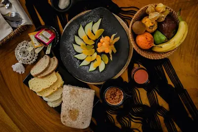 a table with a plate of food with bread and fruit at Éteka Slow Beach Hotel Adults Only in Cartagena de Indias