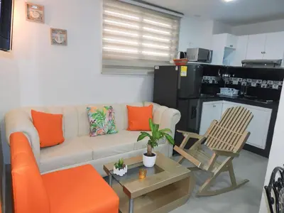 a living room with a white couch and orange pillows at STUDIO DELFINES / BOCAGRANDE in Cartagena de Indias