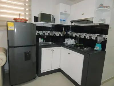 a small kitchen with a refrigerator and a sink at STUDIO DELFINES / BOCAGRANDE in Cartagena de Indias