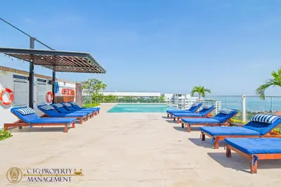 a row of blue lounge chairs next to a swimming pool at Martinique Cartagena, Beautiful 1 & 2 Bedroom Apartments in Cartagena de Indias