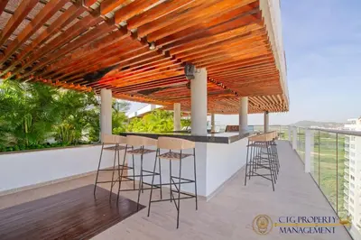 a bar on the roof of a building with stools at Martinique Cartagena, Beautiful 1 & 2 Bedroom Apartments in Cartagena de Indias