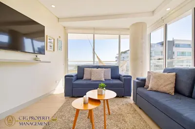 a living room with blue couches and a table at Martinique Cartagena, Beautiful 1 & 2 Bedroom Apartments in Cartagena de Indias