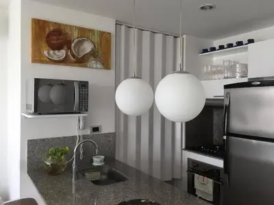 a kitchen with two hanging lights and a refrigerator at Hermoso apartamento con todas las comodidades acceso directo a la playa ubicado en el edificio Morros Epic in Cartagena de Indias