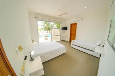 a white room with two beds and a window at Quinta del Mar La Joya in Tolú