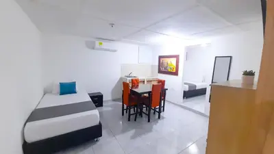 a bedroom with a bed and a table and chairs at Hotel Poblado Suite in Barranquilla