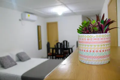 a vase with flowers on a table in a room at Hotel Poblado Suite in Barranquilla