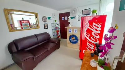 a living room with a couch and a coke machine at Hotel Poblado Suite in Barranquilla