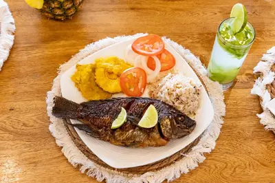 a plate of food with a fish and rice at Marazao Beach Hotel & Spa in Tierra Bomba