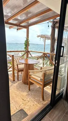 a patio with a table and benches on the beach at Marazao Beach Hotel & Spa in Tierra Bomba