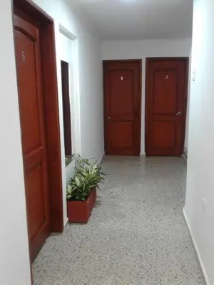 a hallway with three wooden doors and a potted plant at HOTEL CASA GARCES in Cartagena de Indias