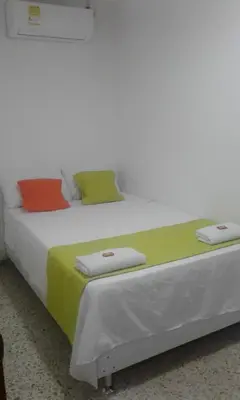 a bed with three pillows on top of it at HOTEL CASA GARCES in Cartagena de Indias