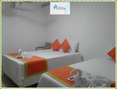 a hotel room with two beds with a swan on it at HOTEL CASA GARCES in Cartagena de Indias