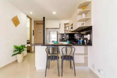 a kitchen with two bar stools and a counter at Cómodo moderno apto en Bocagrande a 2' de la playa in Cartagena de Indias