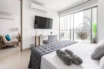 a bedroom with a bed with a television on the wall at Cómodo moderno apto en Bocagrande a 2' de la playa in Cartagena de Indias