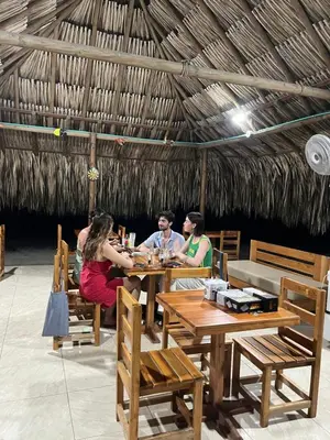 a group of people sitting at tables in a restaurant at Hotel Las Casitas De Mar Adentro in Isla Grande