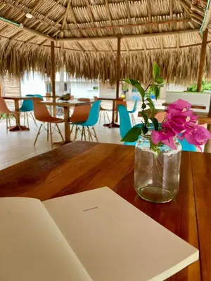 a vase with flowers sitting on a wooden table at Hotel Las Casitas De Mar Adentro in Isla Grande